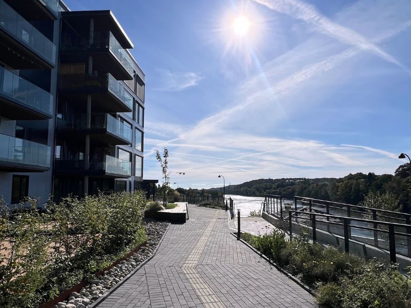 Kokleheia Amfi – moderne leilighetsbygg i Kristiansand med sol og blå himmel